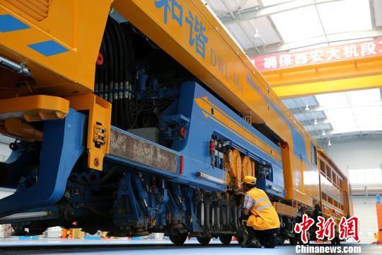 圖為工人正在清理大型養(yǎng)路機械。　張遠 攝